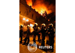 magen de unos antidisturbios junto a un edificio histórico en llamas en el centro de Atenas en la noche del 12 de febrero.