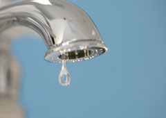 Un grifo del que cae una gota de agua. Un grifo del que cae una gota de agua.