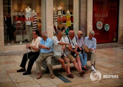 Un grupo de pensionistas sentados en un banco en una calle en el centro de Málaga, el 4 de julio de 2016