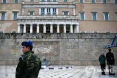 Grecia promete respetar privatizaciones y compromisos fiscales Un guardia griego mira mientras un turista se hace una foto con otro guardia, en la tumba al soldado desconocido en Atenas, el 23 de febrero de 2015