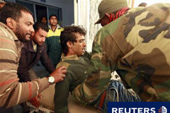 La guerra en Libia, cerca de un punto muerto, según EEUU Un combatiente rebelde ayuda a un colega herido trasladado al hospital de Ajdabiya, el 7 de abirl de 2011.