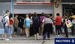 Varias personas hacen cola frente a una oficina de empleo en Madrid