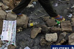 Las irregularidades no invalidan las elecciones de Haití Un haitiano cruza un canal lleno de desperdicios después de que los votantes destruyeran material electoral el domingo, el 29 de noviembre de 2010 en Puerto Príncipe