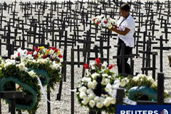 Un sombrío Haití promete no olvidar a las víctimas del terremoto Una mujer deposita flores en la fosa común de Titanyen, en las afueras de Puerto Príncipe, el 11 de enero de 2011.