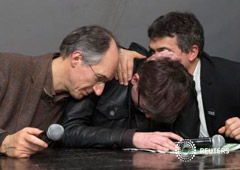 El nuevo editor jefe de Charlie Hebdo Gerard Briard (I) y el columnista Patrick Pelloux consuelan al dibujante Luz (C) durante una conferencia de prensa en París, el 14 de enero de 2015