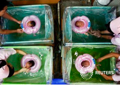 Recién nacidos reciben baños de sus padres y enfermeras en un hospital de Wuhan, capital de la provincia de Hubei, el 19 de agosto de 2006