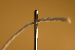 Un hilo entrando en una aguja.