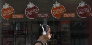 El IVA cultural abre otra brecha entre Gobierno y las CCAA un hombre escucha música al paso de una tienda que informa de que no subirá el IVA,