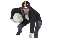 ¡Viva la defensa de los consumidores! Un hombre con casco en posición defensa con la bola del mundo debajo del brazo
