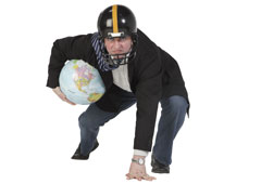 Un hombre con casco en posición defensa con la bola del mundo debajo del brazo