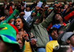 Varias personas canan y bailan en el estadio Soccer City antes del homenaje a Mandela, el 10 de diciembre de 2013