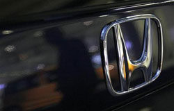 Honda revisará 440.000 coches por fallos del airbag un hombre aparece reflejado en un coche de Honda aparcado frente a la sede de la compañía en Tokio el 3 de febrero de 2010.