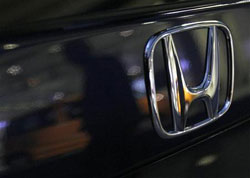 un hombre aparece reflejado en un coche de Honda aparcado frente a la sede de la compañía en Tokio el 3 de febrero de 2010. un hombre aparece reflejado en un coche de Honda aparcado frente a la sede de la compañía en Tokio el 3 de febrero de 2010.