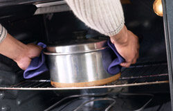 A punto de salir del horno el sistema de protección de Autónomos Unas manos sacando la comida del horno.