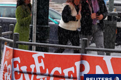 Portugal, en huelga general contra las medidas de austeridad La gente camina al lado de una pancarta anunciando la huelga general