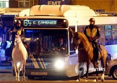 Agentes de la Policía montada escoltan a un autobús del servicio municipal a su salida de cocheras en el inicio de una huelga general en Madrid, el 14 de noviembre de 2012