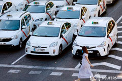 Los taxistas españoles debaten si continúan con la huelga Una mujer cruza por un paso de cebra del Paseo de la Castellana en Madrid ante una concentración de taxis con motivo de la huelga, el 31 de julio de 2018