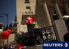 En la imagen de archivo, una funcionaria lanza una bandera de UGT a la sede del Banco de España en Málaga, durante una huelga del sector público, el 8 de junio de 2010.