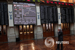 El Ibex 35 baja a mediodía en espera de un acuerdo sobre Grecia Un comerciante se ve en las tablas de índices de acciones en la Bolsa de Madrid