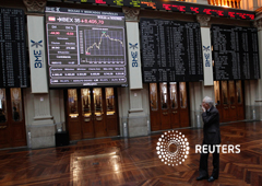 Un comerciante se ve en las tablas de índices de acciones en la Bolsa de Madrid