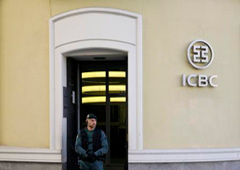 Un agente de la Guardia Civil en la puerta de la entidad durante el registro de la sede del banco en Madrid, el 17 de febrero de 2016