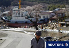 Un hombre camina delante de un barco arrastrado por el tsunami del 11 de marzo, en Ofunato, en la prefectura de Iwate, el 18 de abril de 2011.