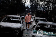 Familias unidas en un último abrazo, entre los 74 muertos por incendios en Grecia Un hombre camina entre coches calcinados tras un fuego en el pueblo de Mati, cerca de Atenas, Grecia, 24 de julio de 2018