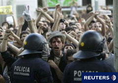 Policías antidisturbios frente a manifestantes apostados a las puertas del Parlament el 15 de junio de 2011 en Barcelona.