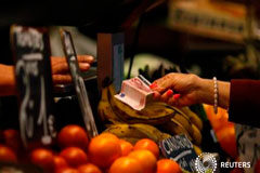 El aumento de la inflación se ralentiza en marzo Un cliente en un puesto de fruta en Málaga en abril de 2012