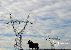 Unas torres de luz cerca de un cartel del toro en la localidad asturiana de El Berron, cerca de Oviedo, el pasado 26 de diciembre