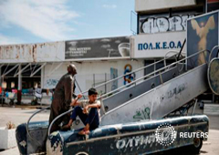 Un niño sentado junto a una estatua en el aeropuerto en desuso de Hellenikon, donde se aloja temporalmente a inmigrnates, en Atenas, el 3 de mayo de 2016