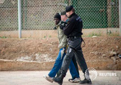 Un inmigrante escoltado por guardias civiles en Melilla es devuelto a Marruecos el 2 de diciembre de 2014