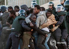 Inmigrantes subsaharianos rodeados por la Guardia Civil española en el puesto fronterizo entre Marruecos y Melilla, el 24 de abril de 2014