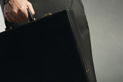 Una mano sujetando un maletín negro.