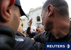 Unos policías trata de calmar a manifestantes progubernamentales en Túnez, el 25 de enero de 2011.