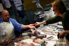 El IPC cayó un 1,3% mensual en enero y la tasa anual baja al 0,2% Una mujer compra en una pescadería en el centro de Madrid, el 30 de julio de 2013