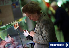 Una clienta compra en una carnicería de Madrid el 12 de abril de 2011.