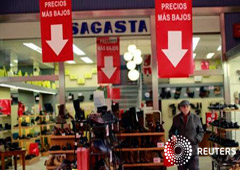 Un hombre camina pasando bajo pancartas que decían Un hombre camina pasando bajo pancartas que decían