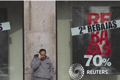 El IPC de España baja al 2% interanual en enero Un hombre habla por su móvil delante de un escaparate de una tienda que anuncia unas segundas rebajas en la Puerta del Sol, en Madrid, el 14 de enero de 2012