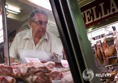 Un carnicero coloca su mercancía en el mercado de Chamberí en Madrid