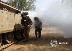 Soldados israelíes pasan por una columna de humo durante un entrenamiento de guerrilla urbana cerca de la línea de alto el fuego entre Israel y Siria en la zona ocupada por Israel de los Altos del Golán, el 6 de mayo de 2013