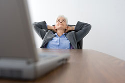 Una mujer con el pelo blanco estirándose en una silla de oficina