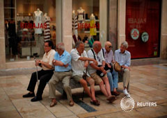 Unos jubilados hablan sentados en un banco en el centro de Málaga el 4 de julio de 2016