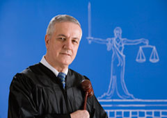 Un juez con una maza y la imagen de la justicia al fondo