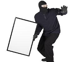 Un ladron vestido de negro con un cuadro en la mano