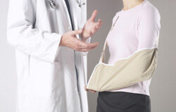 Una mirada profesional a la Valoración de las Lesiones Una mujer con el brazo lesionado hablando con un medico.