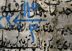 Letras árabes pintadas en una pared.
