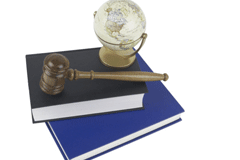 Práctica Jurídica domina el panorama Un mazo y una pequeña bola del mundo encima de dos libros