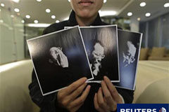 El encarcelado disidente chino Liu gana el Nobel de la Paz Liu Xia, mujer de Liu Xiaobo, muestra fotos del disidente chino durante una entrevista en Pekín el 3 de octubre de 2010.