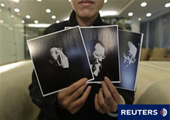 Liu Xia, mujer de Liu Xiaobo, muestra fotos del disidente chino durante una entrevista en Pekín el 3 de octubre de 2010.